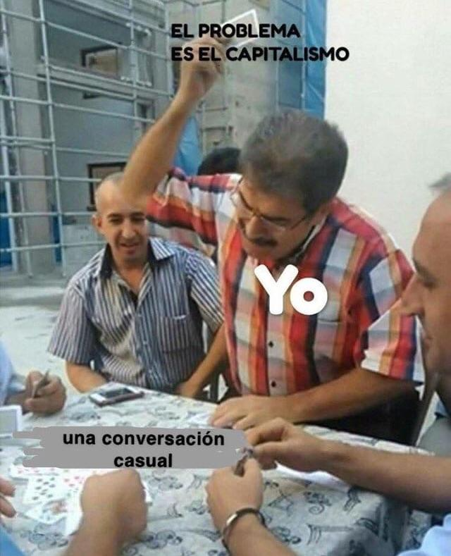 Meme de un señor a punto de tirar una carta a la mesa mientras juega a las cartas con otras personas. En la carta pone: El problema es el capitalismo. En el señor pone: Yo. En la mesa pone: Una conversación casual.
