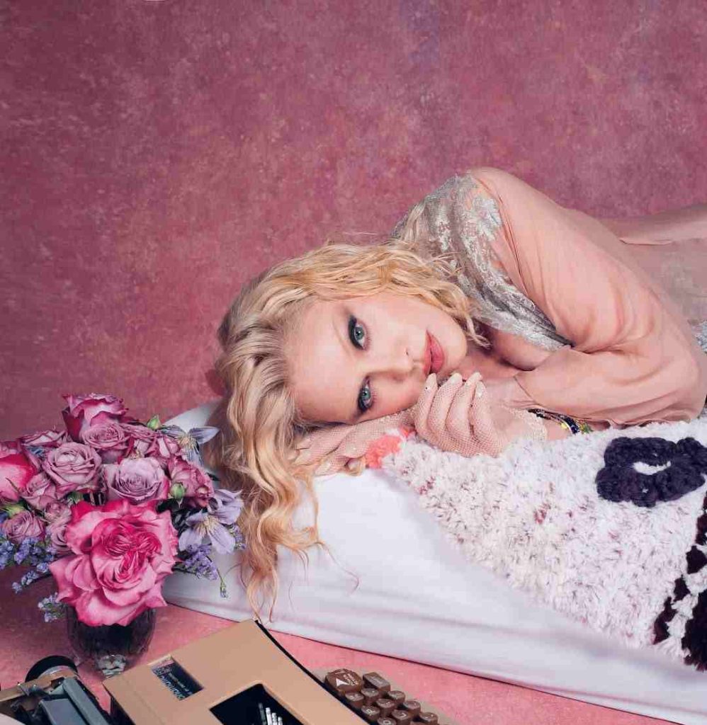 Madonna tumbada en una especie de cama en un cartel promocional de su nuevo disco.