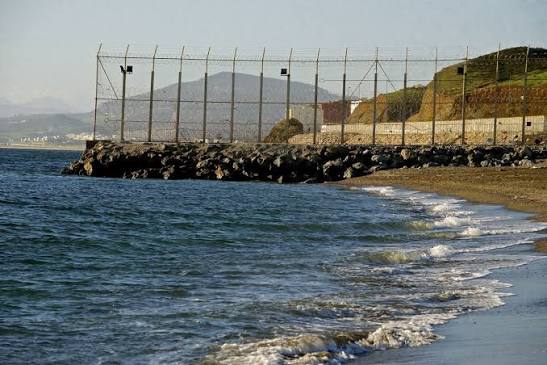 Costa y playa de El Tarajal con la valla metálica en el fondo.